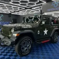 Technician applying car window tint film with squeegee