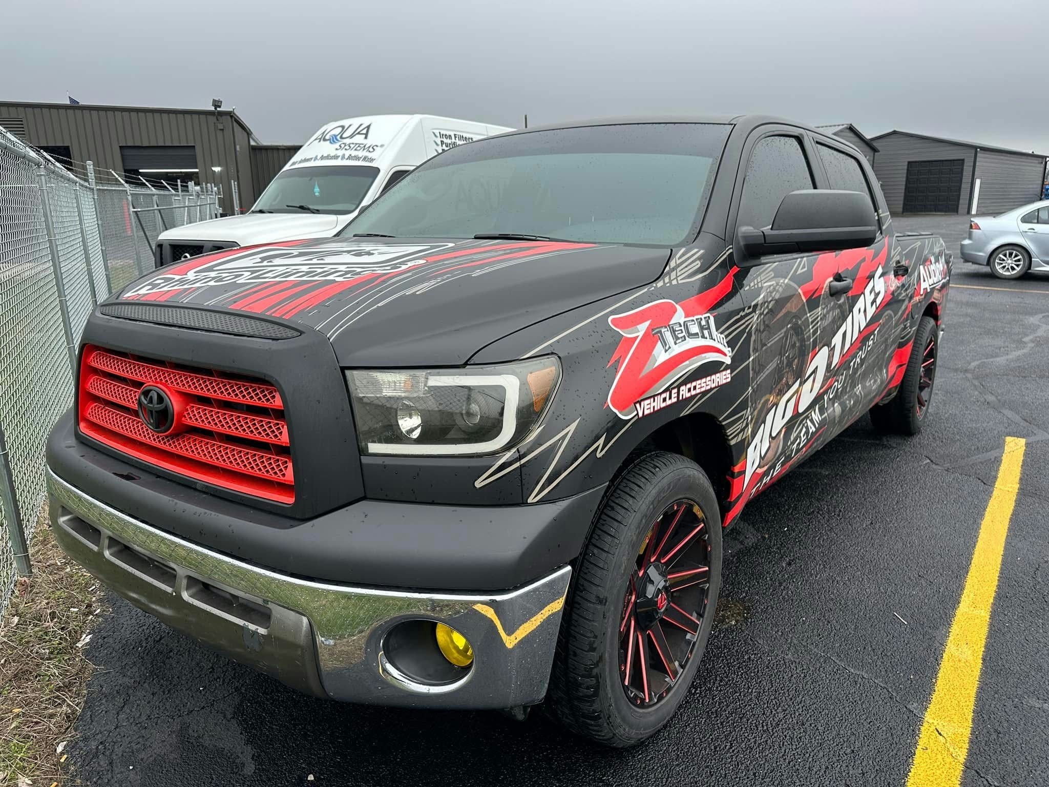 Technician applying car window tint film with squeegee