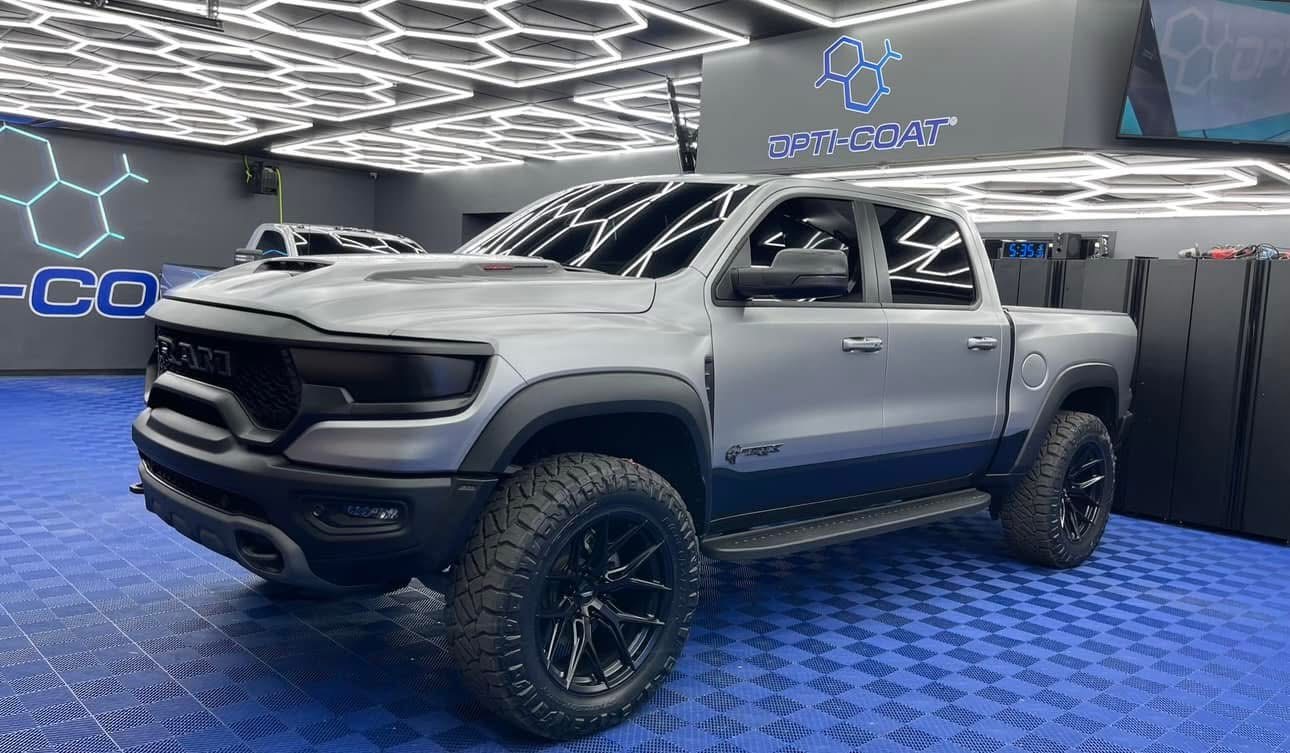 Technician applying car window tint film with squeegee