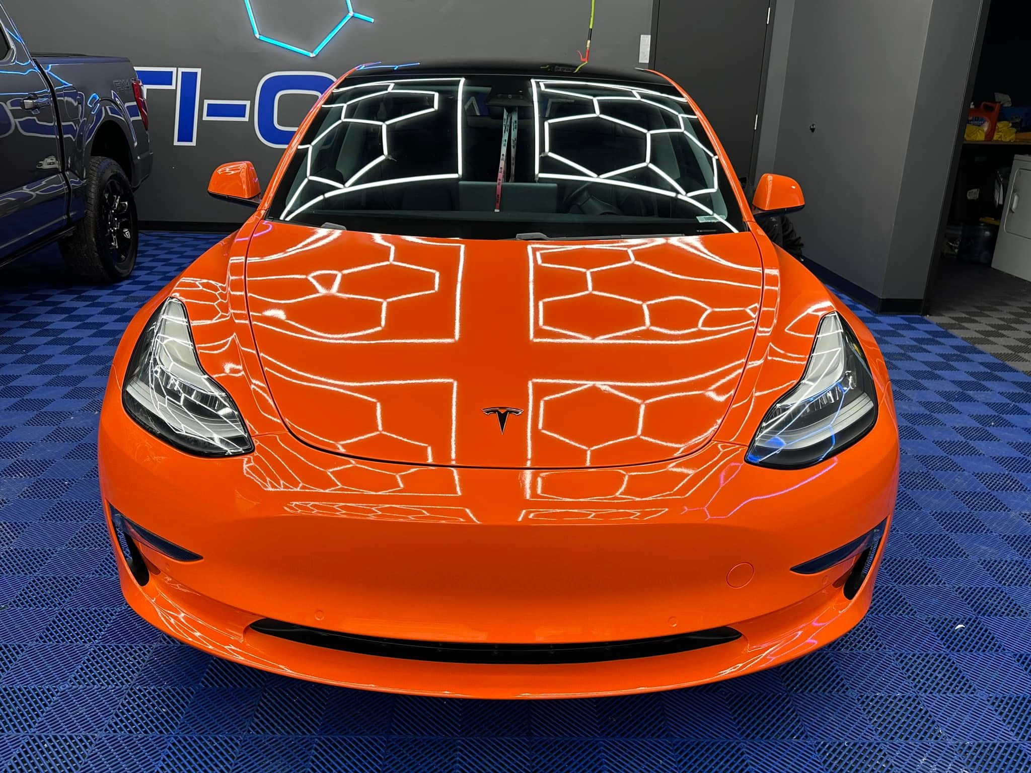 Technician applying car window tint film with squeegee