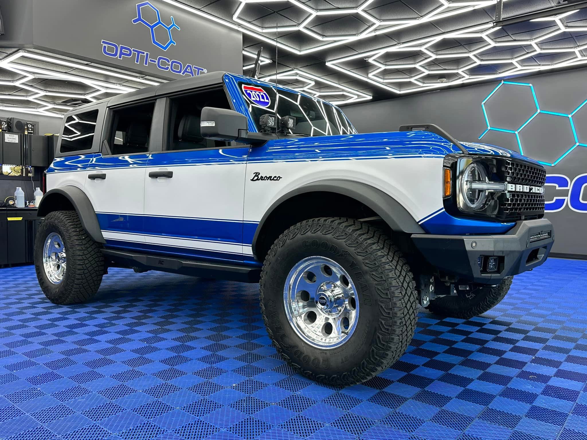 Technician applying car window tint film with squeegee