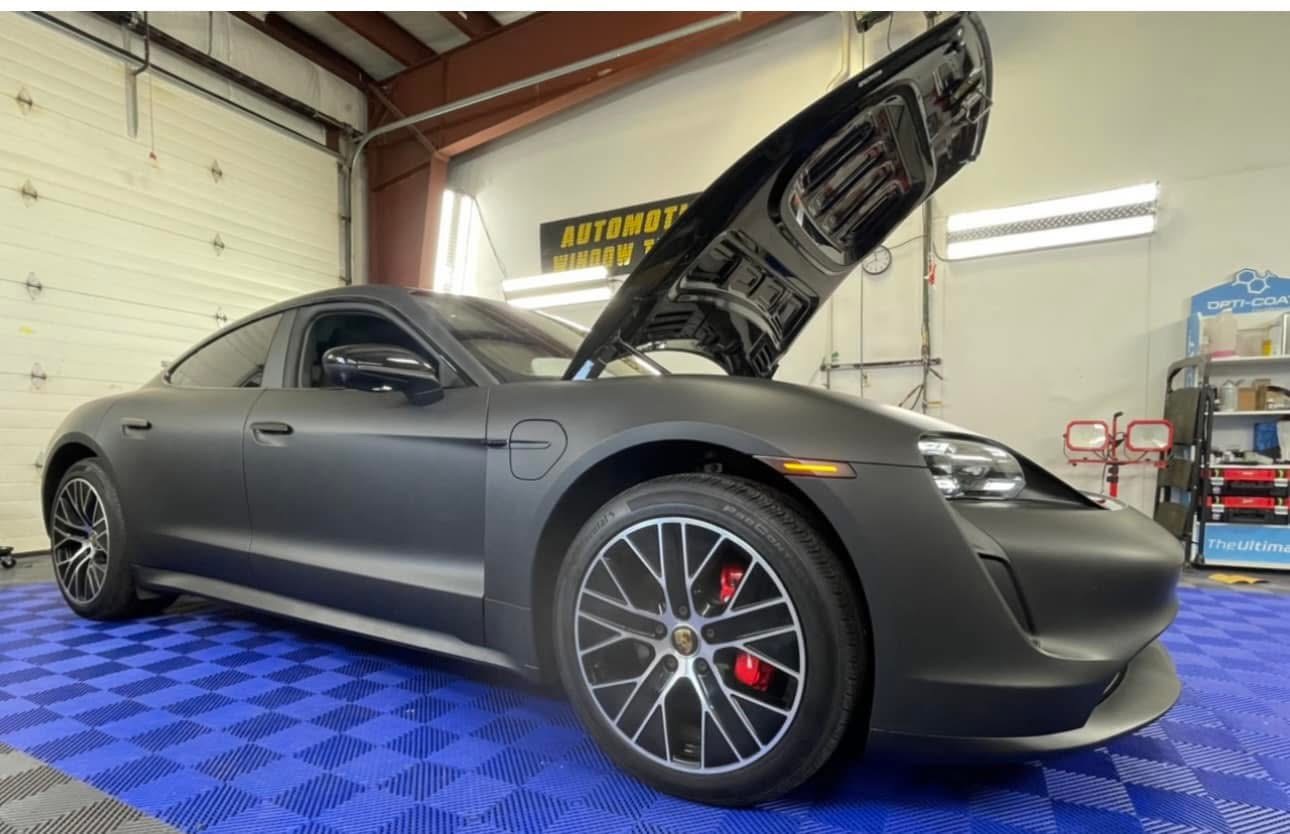 Technician applying car window tint film with squeegee