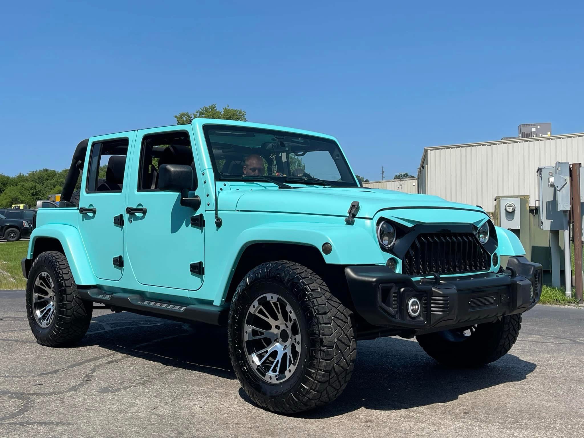 Technician applying car window tint film with squeegee
