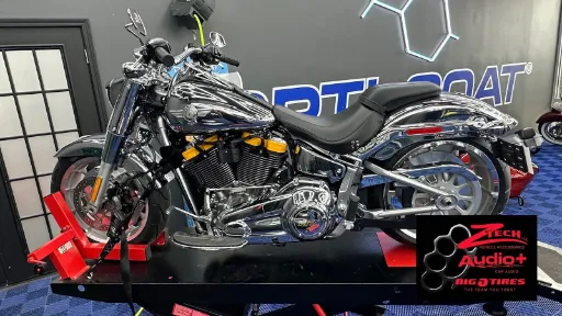 White sports coupe parked on concrete in front of a light-colored building, shown in a front three‑quarter view