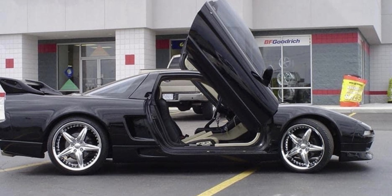 Professional installing window tint on car door glass