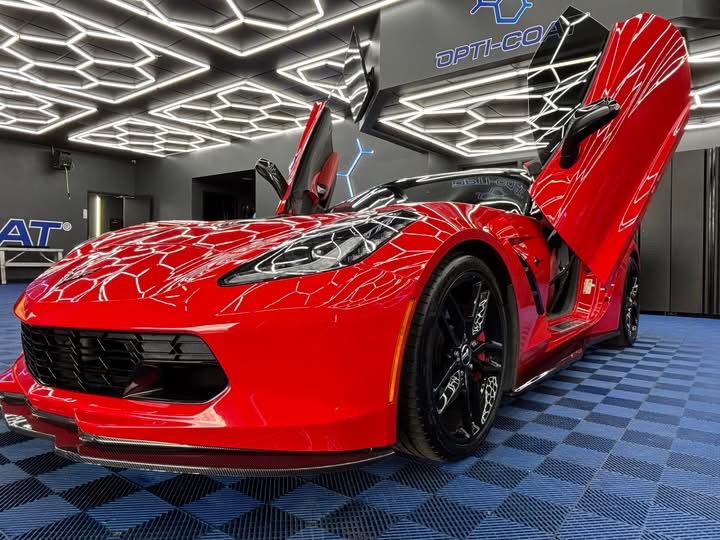 SilhouettWorker preparing and cutting window tint film for care of a masked person in a hood and gloves prying open a car window with a flashlight