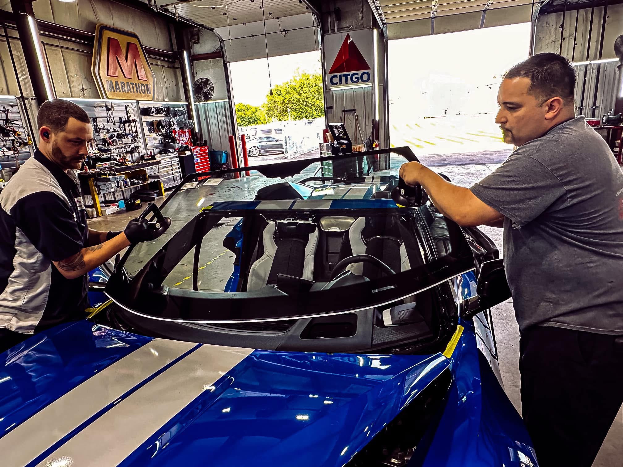 Technician applying car window tint film with squeegee