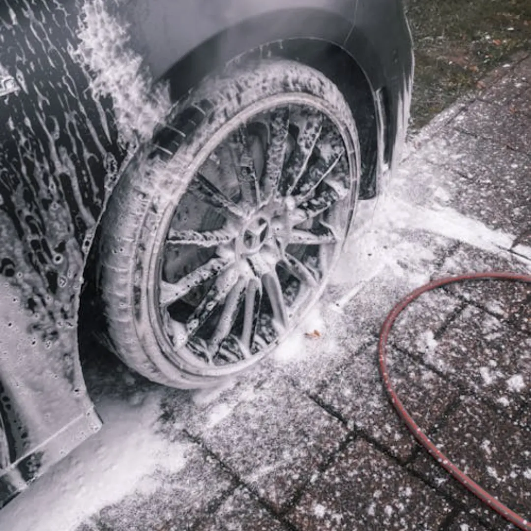 Close up of car wheel being cleaned with high pressure water during car wash
