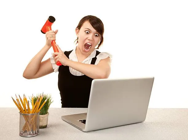 Simplify Your Tech woman hitting laptop with a sledgehammer
