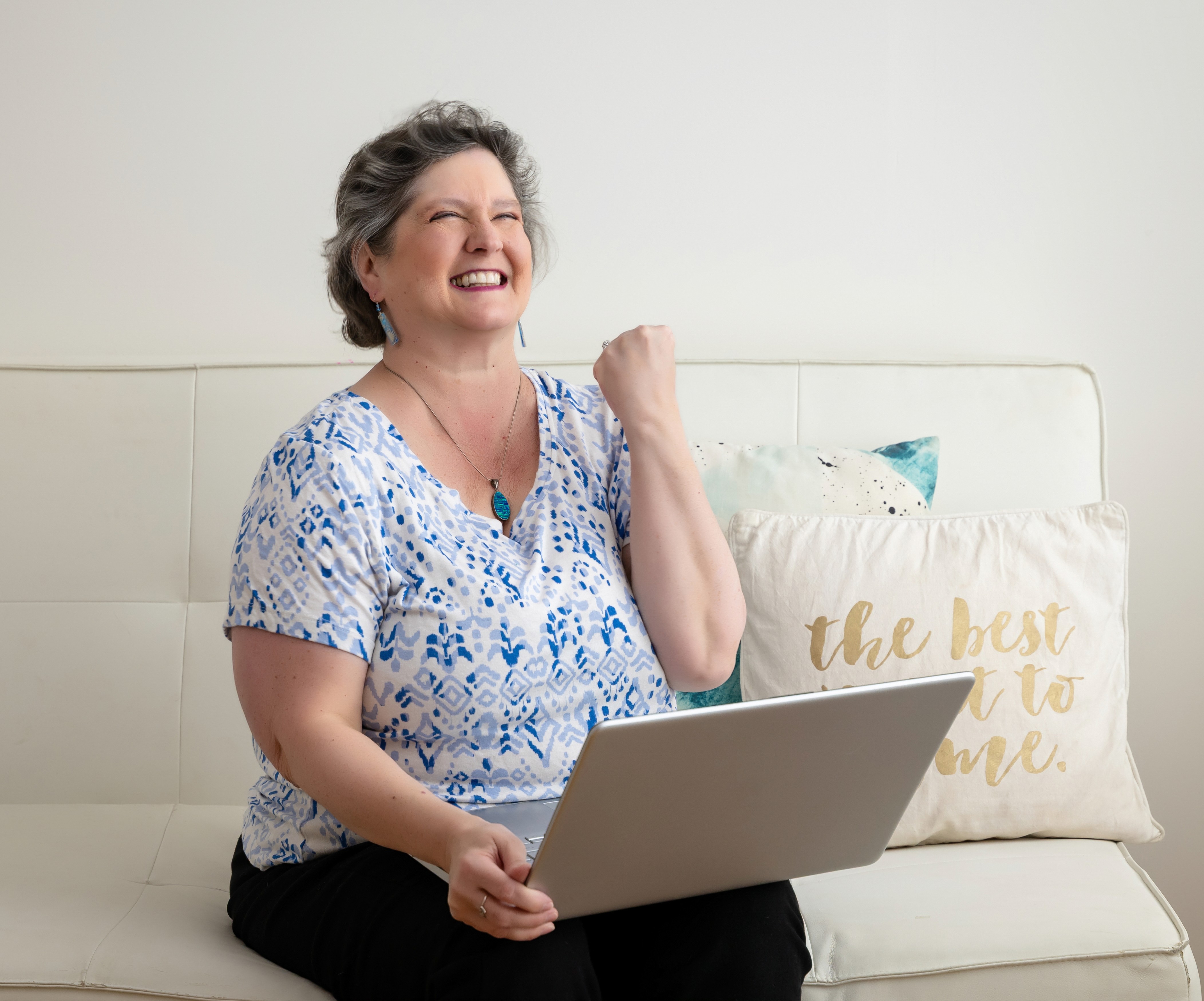 Simplify Your Tech Kat celebrating with laptop