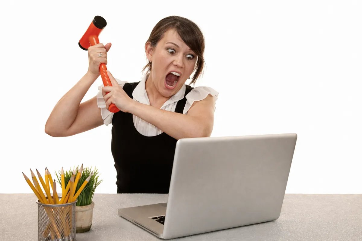 Simplify Your Tech angry woman slegehammering laptop