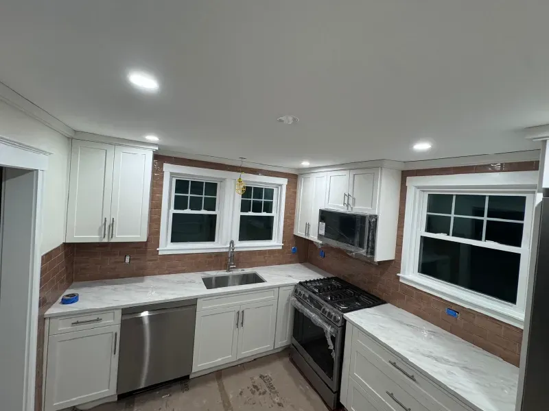 Kitchen renovation with terracotta subway tile backsplash installation, white shaker cabinets, and marble countertops by CLA New England Tile – Boston MA