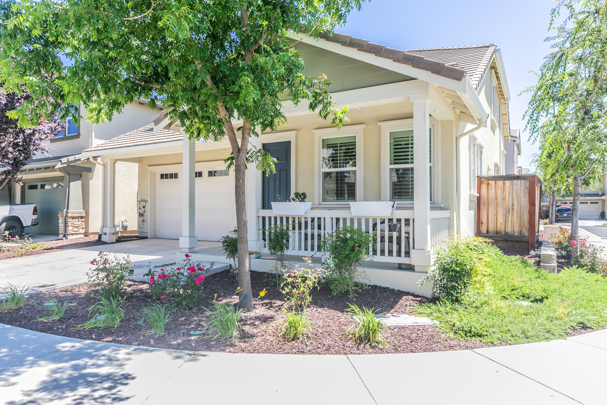A brick house with a green lawn and trees.