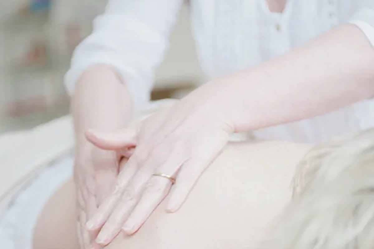 A close-up of a professional therapist massaging a patient's hand and wrist to relieve muscle tension and chronic pain.