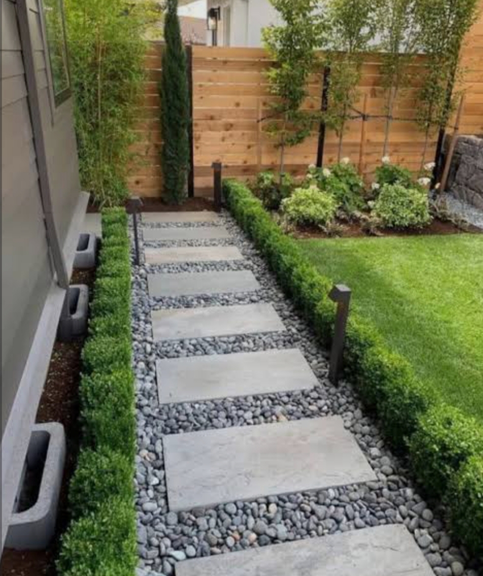 Muro de piedra natural con setos redondeados y plantas ornamentales en talud ajardinado - Jardinería y Paisajismo JS