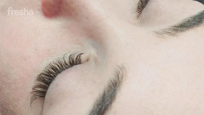 person standing on rock formation surrounded by body of water