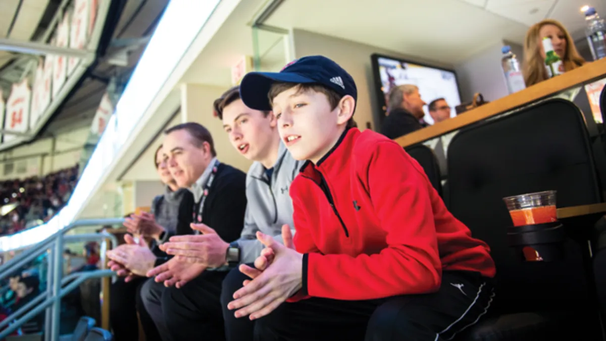 a crowd of people at a concert with their hands in the air
