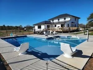 Custom in-ground pool installation in Charlotte NC with built-in seating by AllPhase Exteriors & More