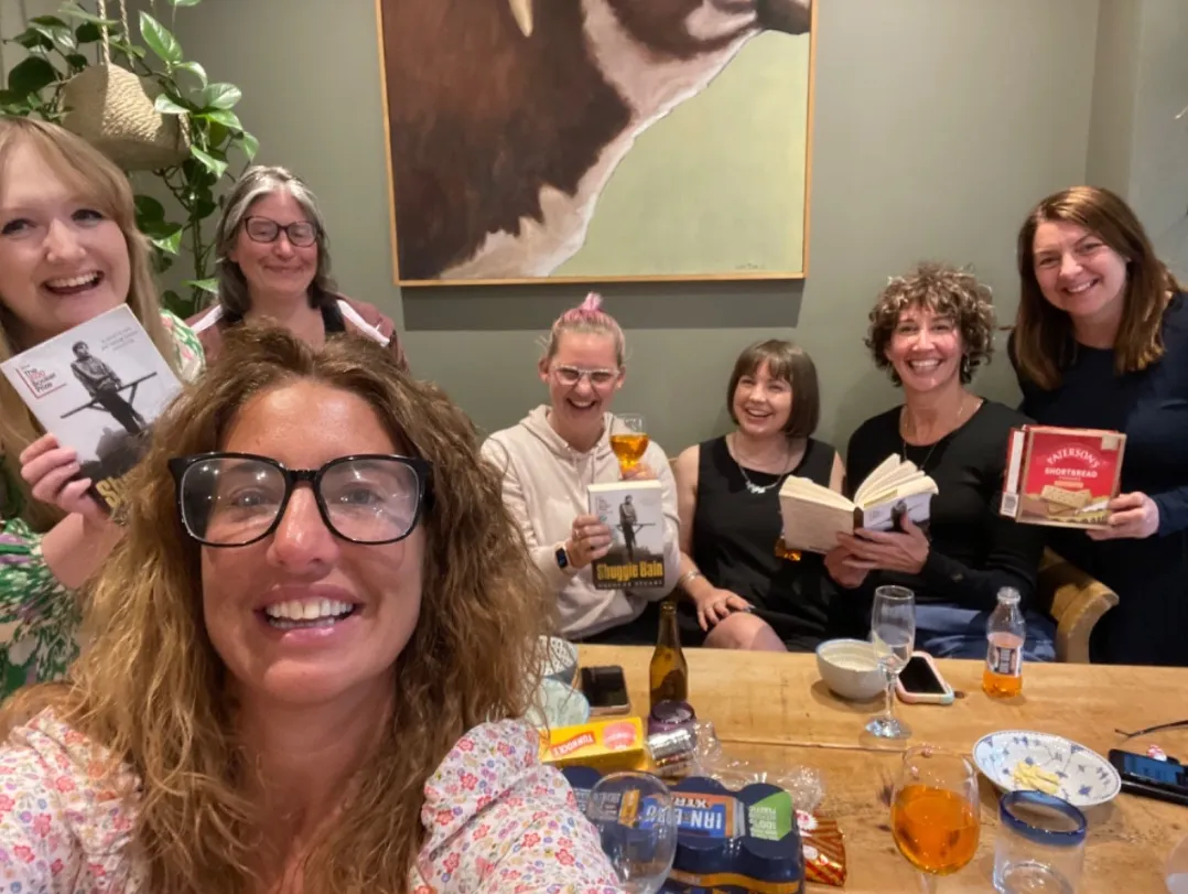 Group of women holding books and smiling