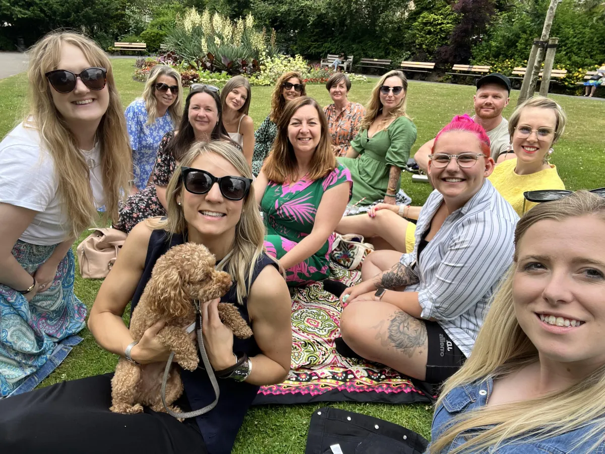 Group of young women and a dog having a picnic in a park