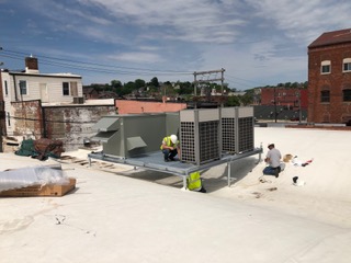 Rooftop HVAC units installed and serviced on a commercial building.
