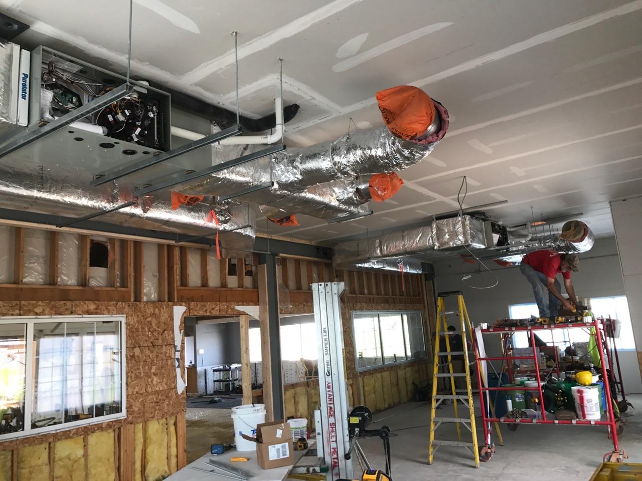 HVAC ductwork installation inside a commercial building with exposed ceiling.