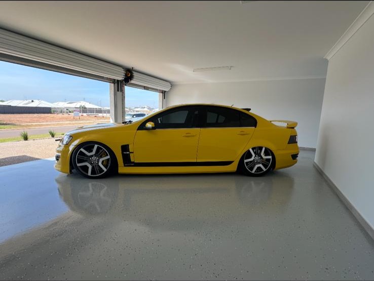 yellow car parked in 4 car garage with epoxy flake floor