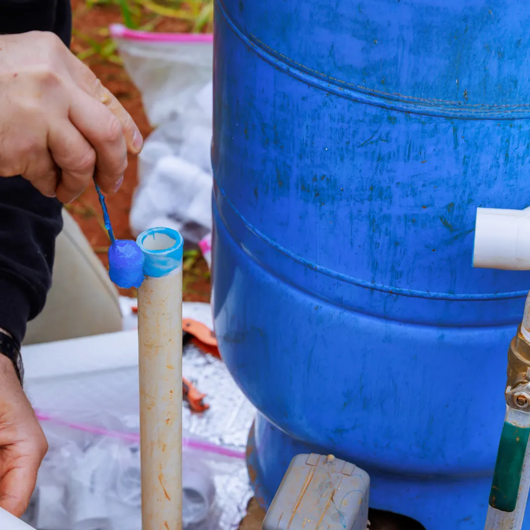 A plumber installing and maintaining a well tank and pump system to ensure a consistent water supply to the home.