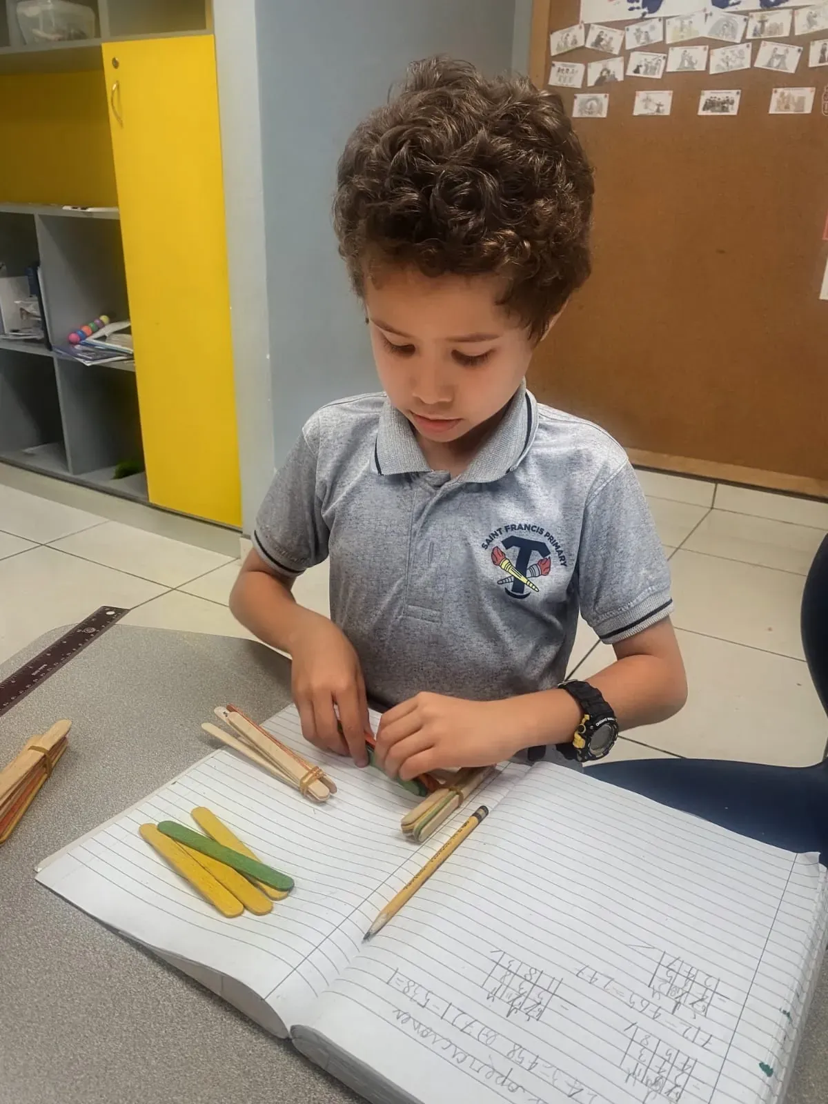 Estudiante de Primaria resolviendo operaciones con palitos de colores