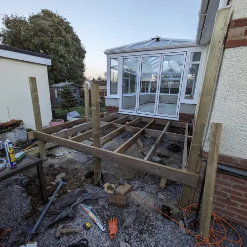 Timber decking construction beside conservatory in Bournemouth home