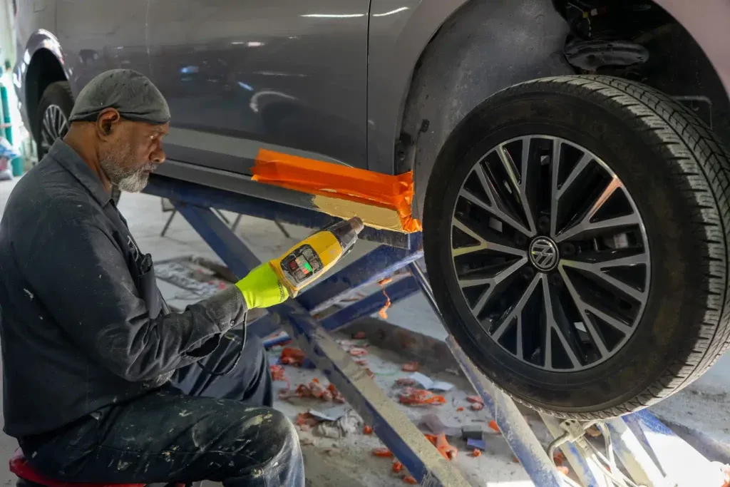 Mechanic examining the undercarriage of a car on a lift