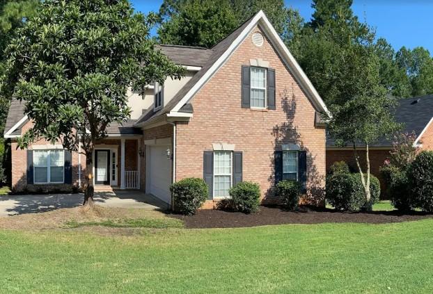 Neatly mowed front lawn with clean-cut hedges and small decorative trees in Augusta GA