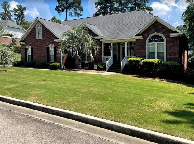 Crisp lawn with small palm trees and trimmed grass in a sunny Augusta GA neighborhood