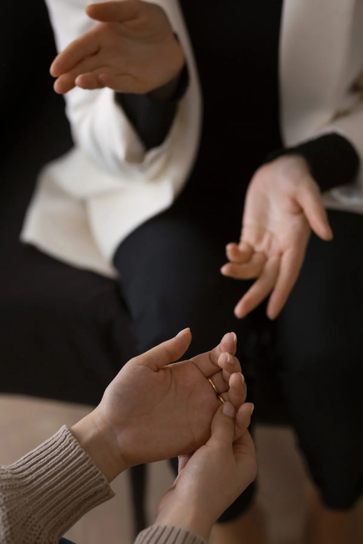Two people in conversation, one gently holding the other's hand