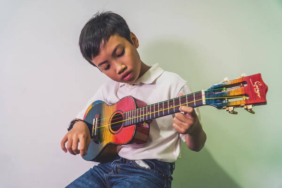 Adult beginner playing ukulele in a friendly small group class at a modern music school