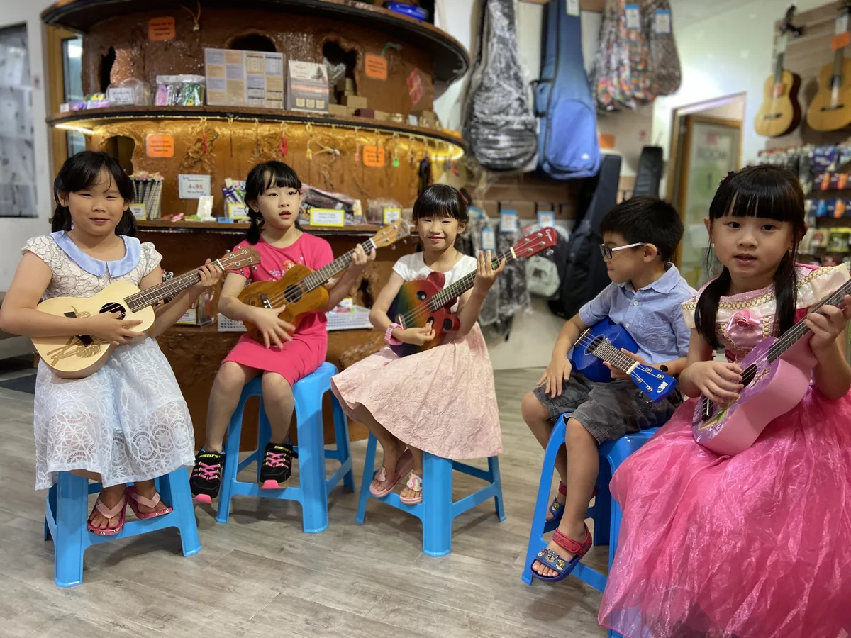 Group of adults and family enjoying ukulele together in a relaxed music class
