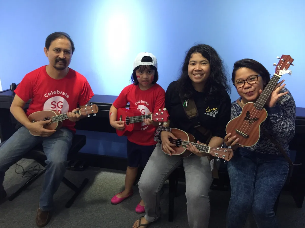 Enthusiastic student holding a ukulele confidently