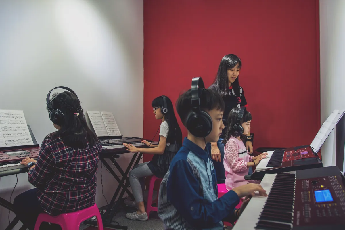 Diverse group of students learning keyboards together in a supportive group class