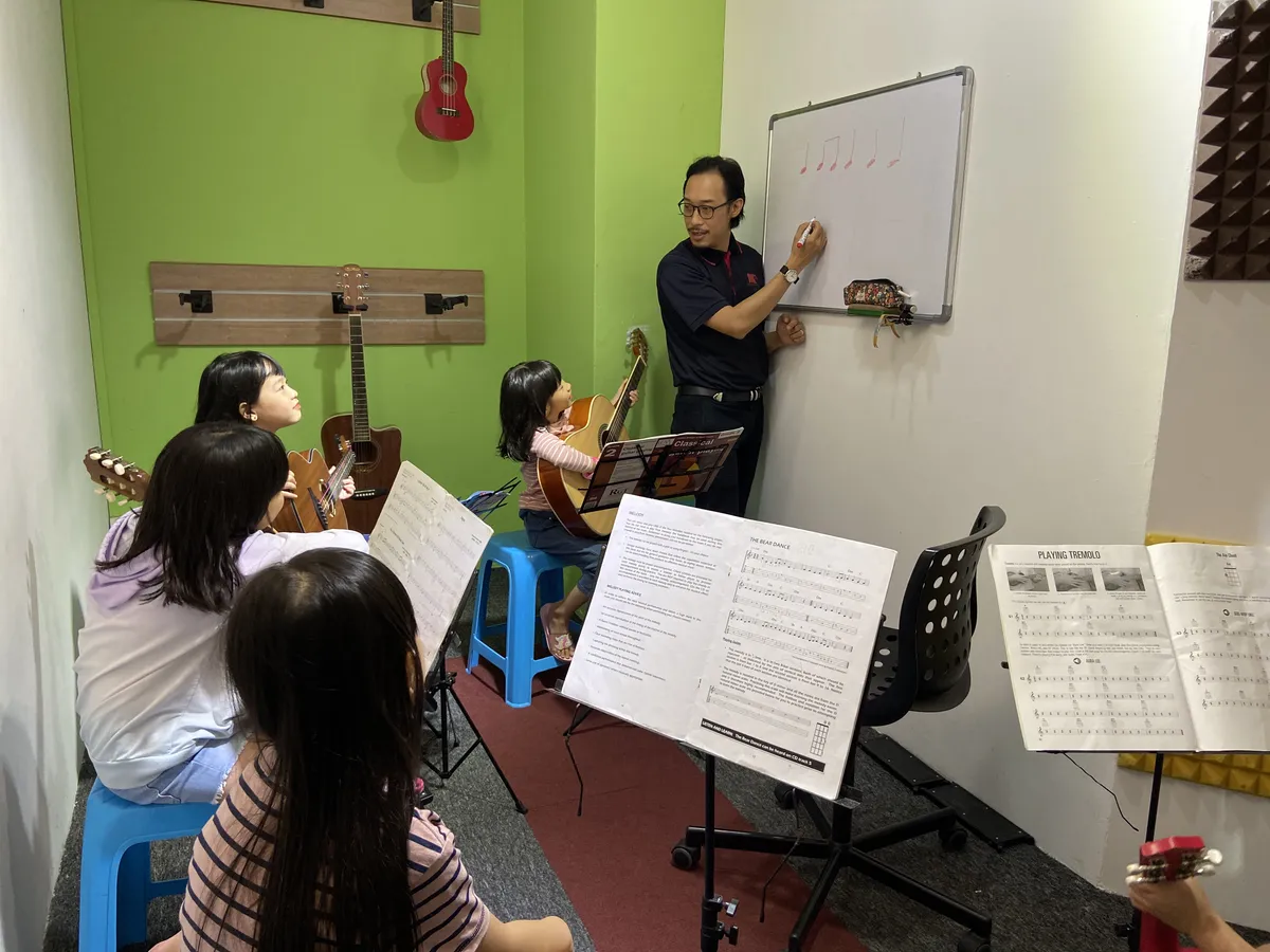 Student annotating sheet music and music notation during a music theory lesson