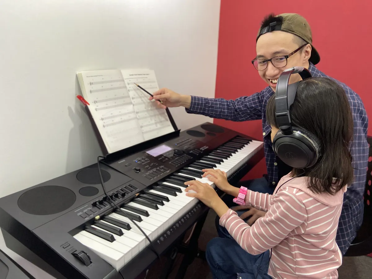 Student studying music theory with sheet music and notation in a modern classroom setting