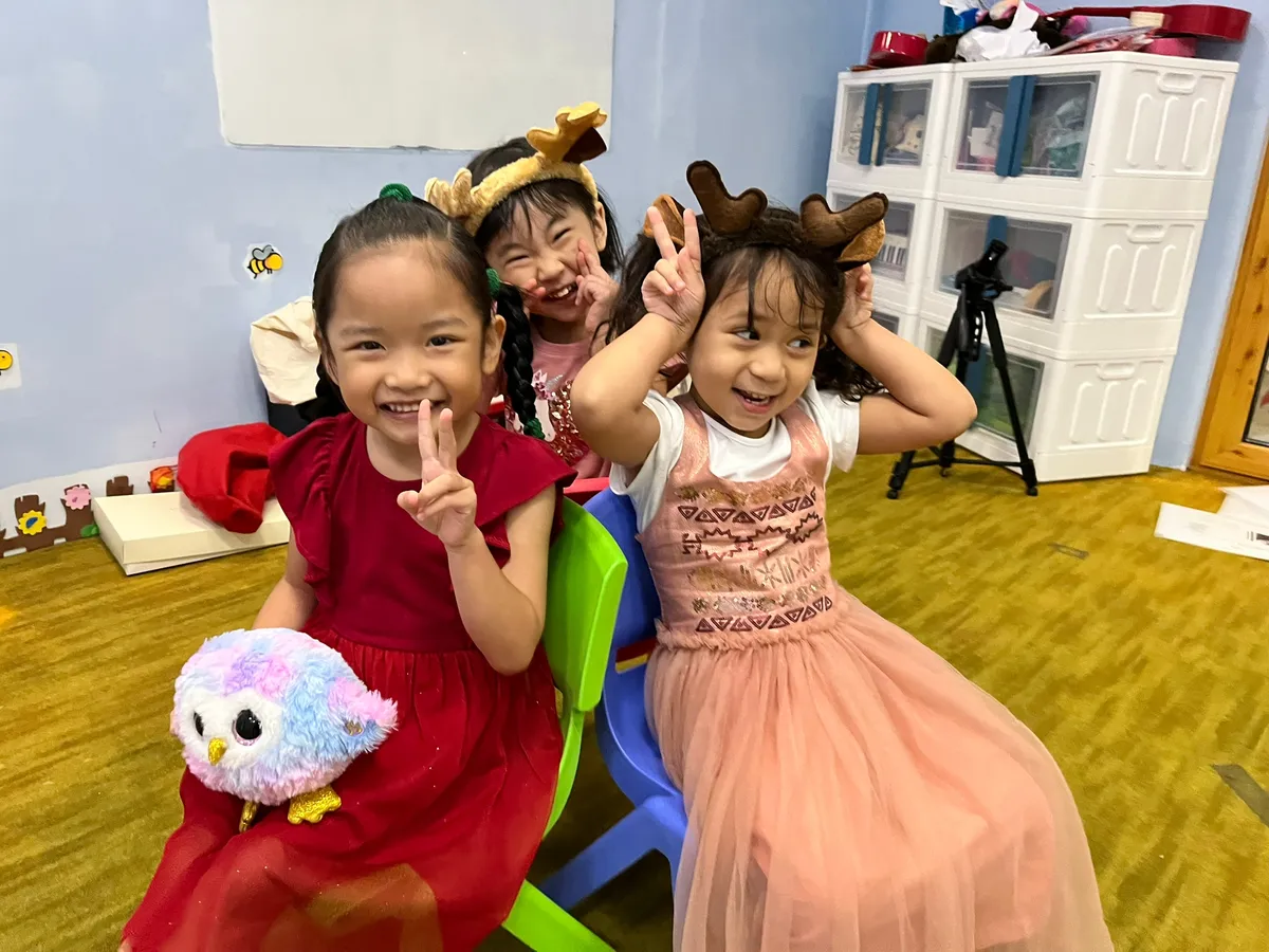 Small group early-childhood music class for ages 2.5–5 exploring bells and keyboards in a warm, modern music school setting
