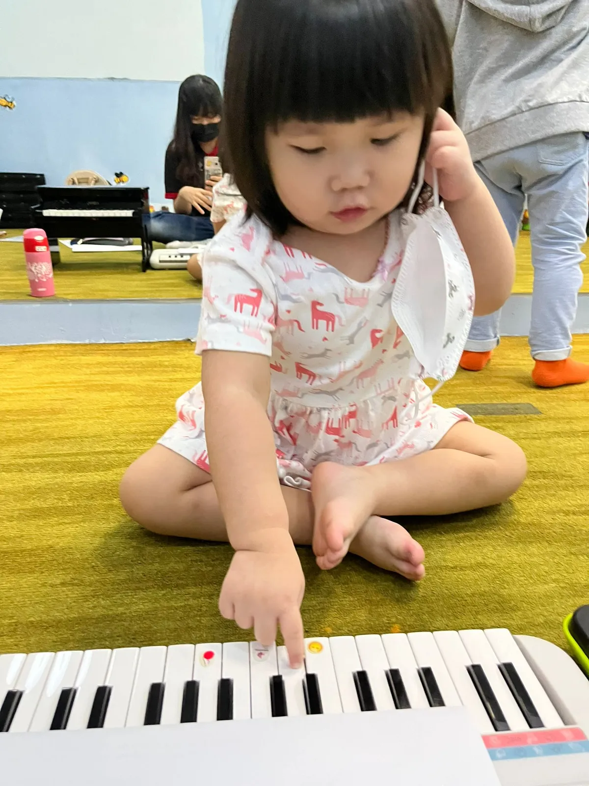 Child exploring colourful resonator bells in a warm, welcoming music class