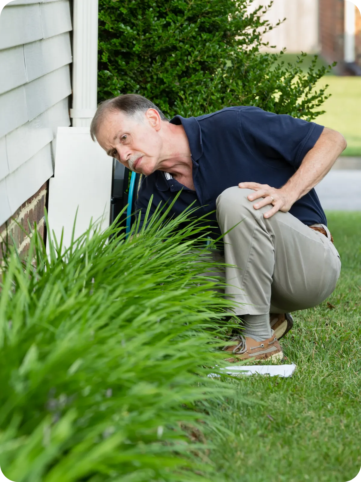 Home inspector examining the exterior foundation of an older house — representing expert antique and old home inspections in Fort Collins, CO.