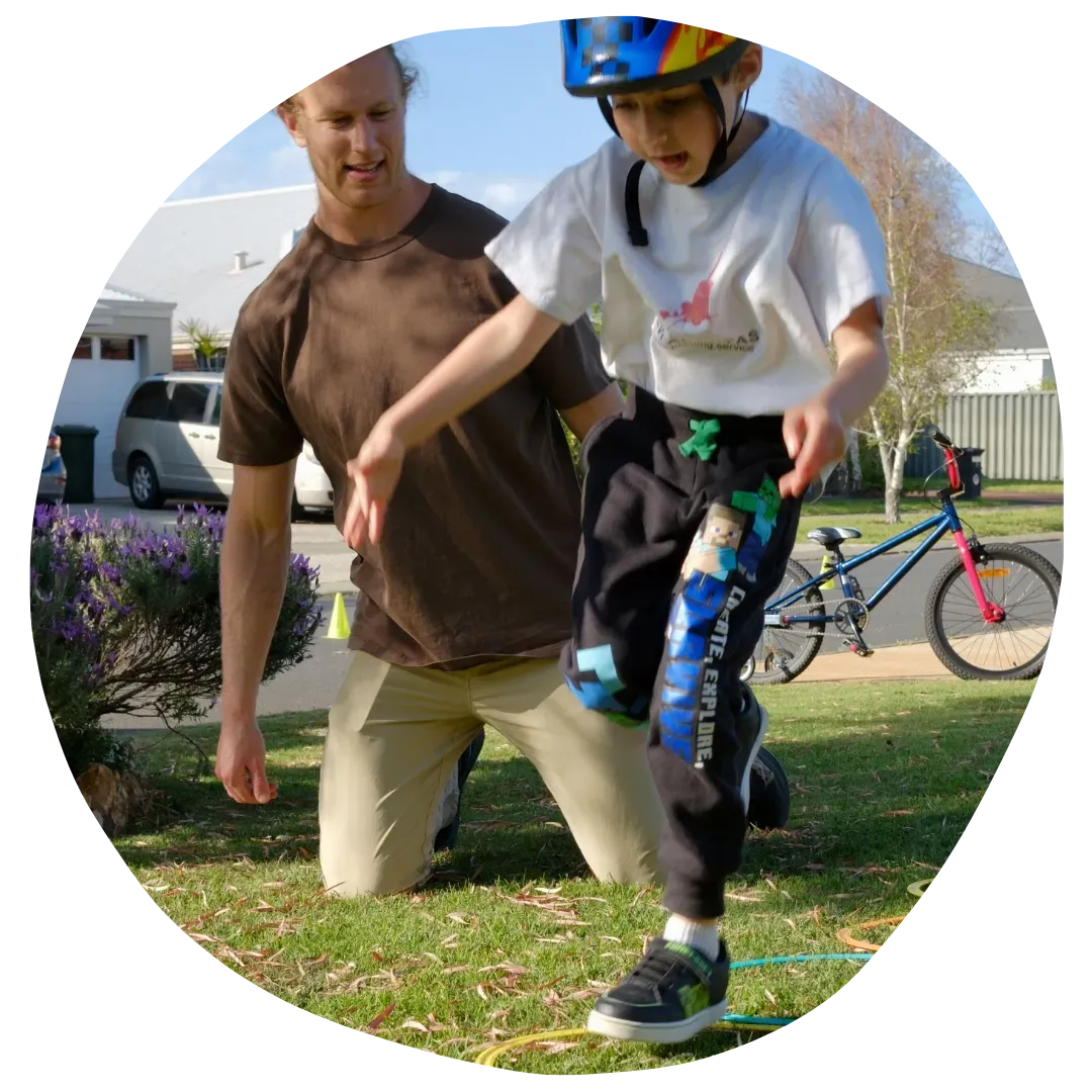 Paediatric Physiotherapist Assisting Kid Ride a Bike