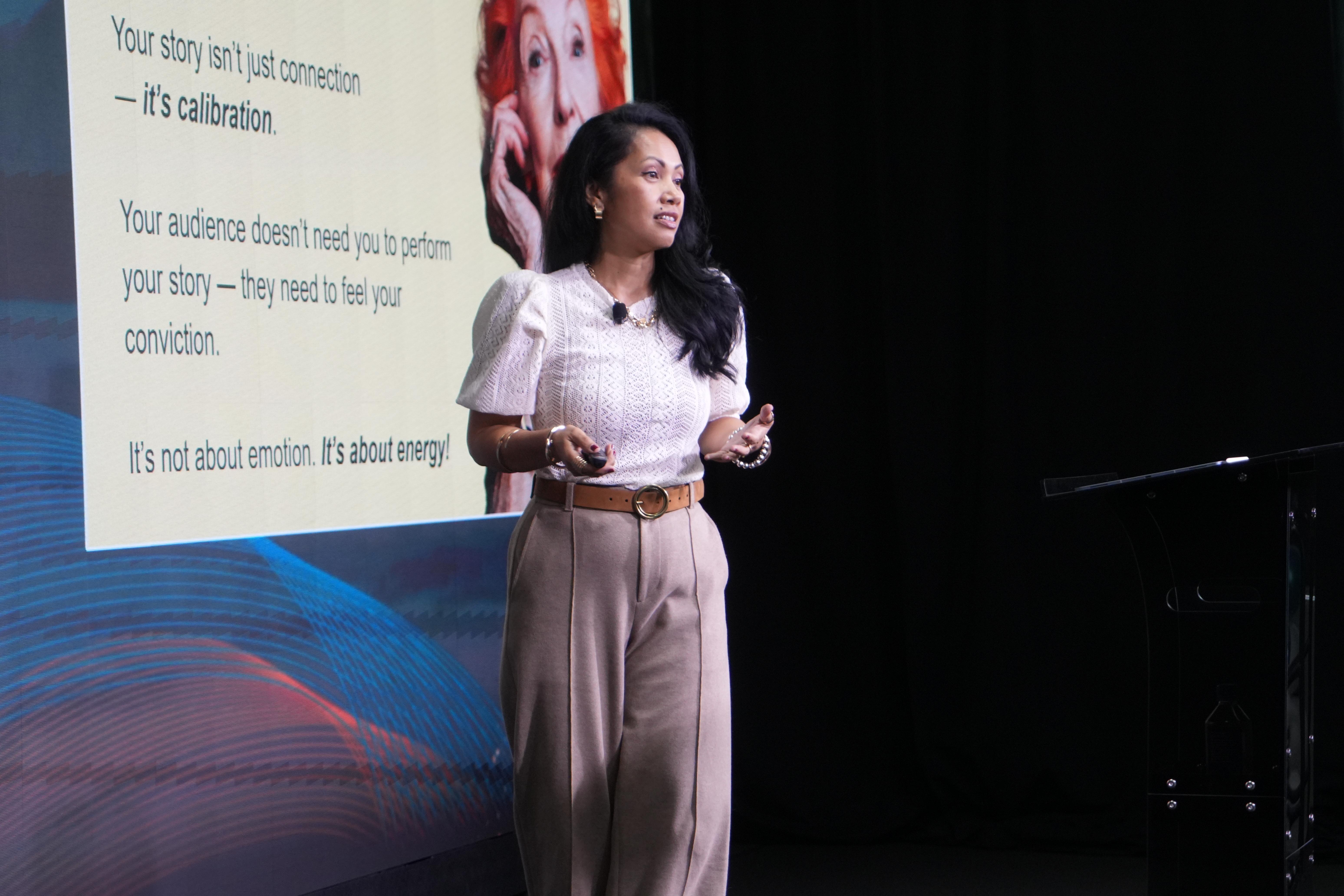 Speaker presenting on stage to an engaged audience