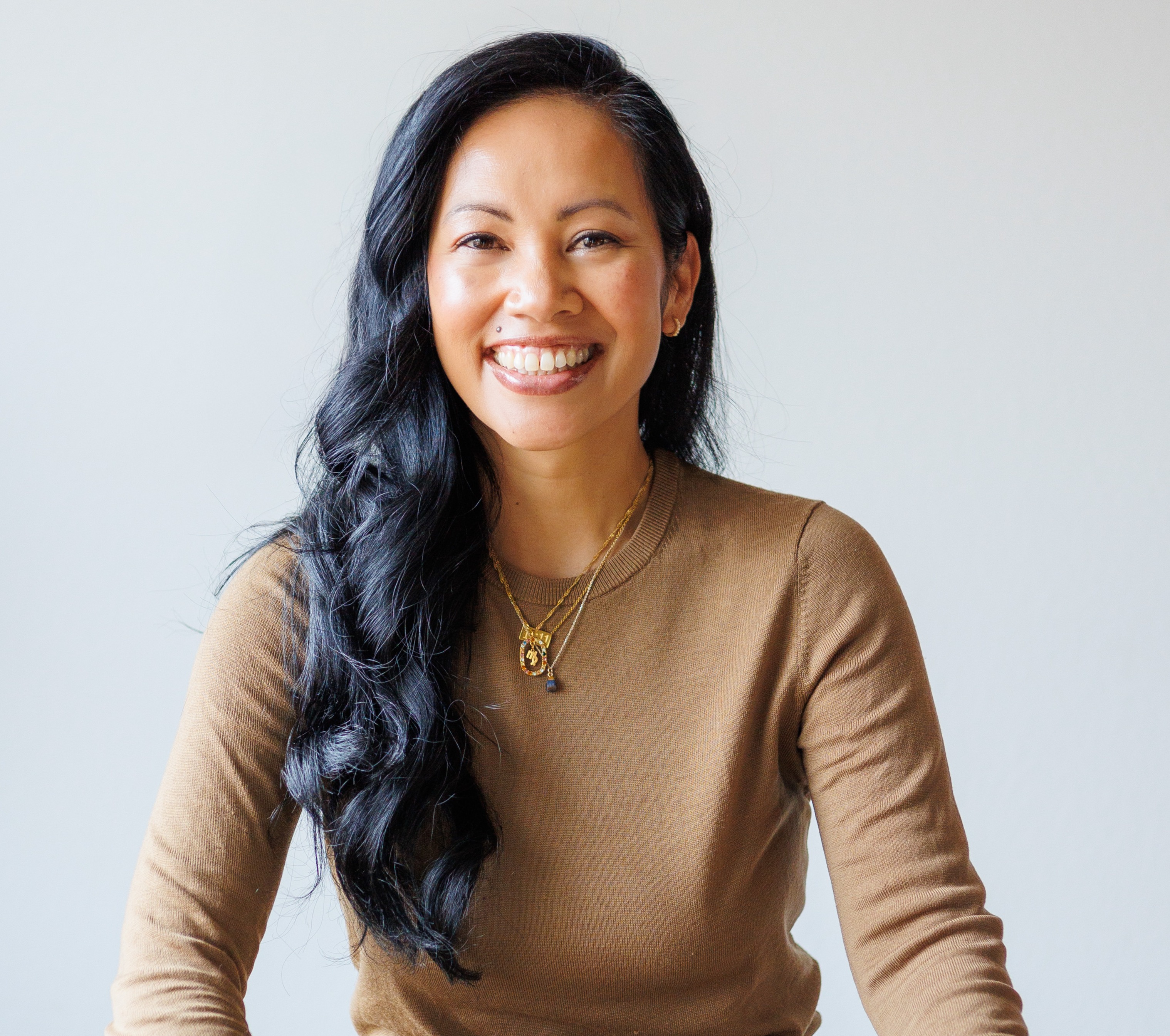 Cat Coley Sitting on table cross legged big smile full of energy