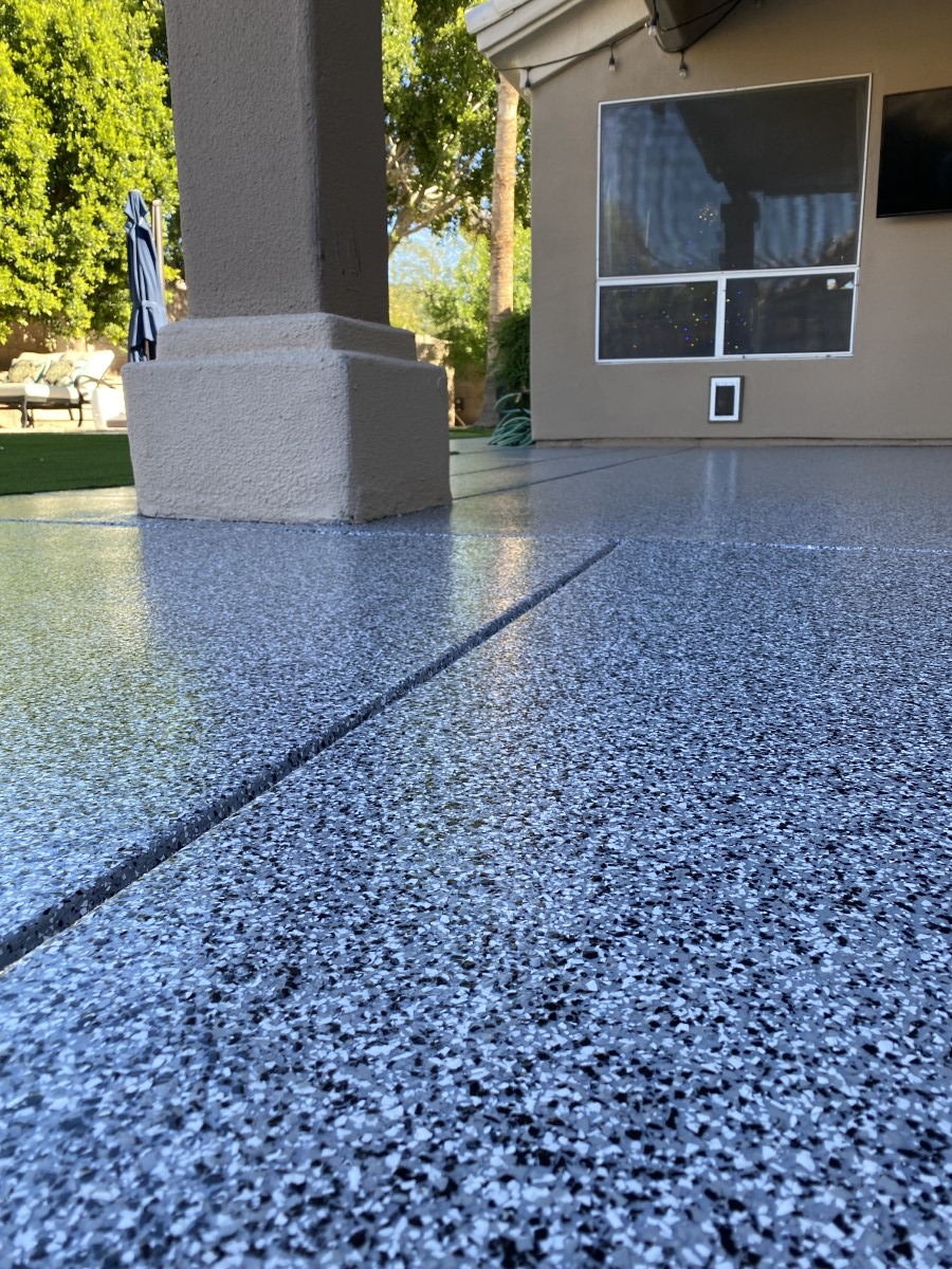 Close-up of textured epoxy flake concrete coating on outdoor patio surface