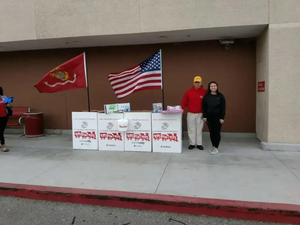 Bob Martinez has set up the Toys for Tots collection boxes in front of our new sight at the Target Store, Sycamore Square Mall on Cochran Street. Here he is with a young girl who passed by, said “I’ll be back” and then returned a few minutes later with a number of toys for the program.