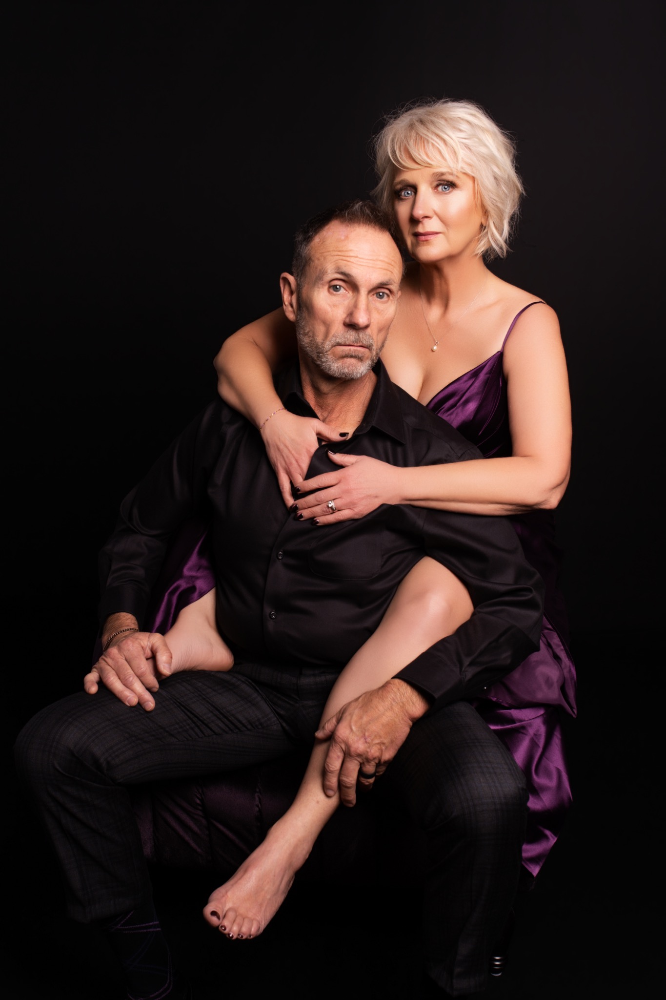 Confident couple portrait with a purple gown and black shirt