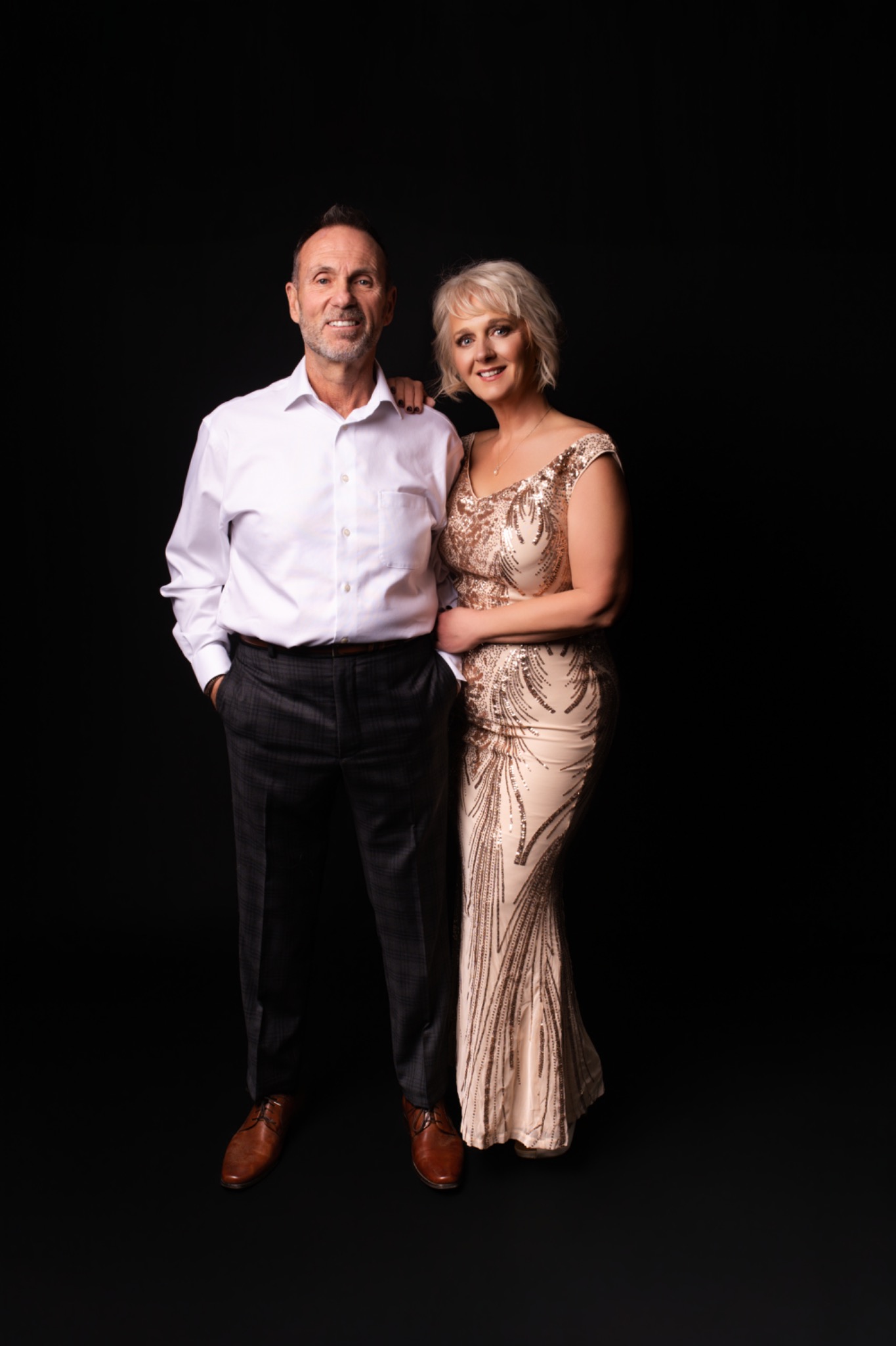 Full-length couple portrait in a gold gown and white shirt